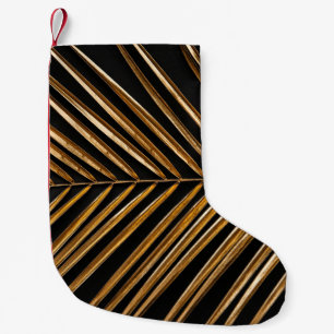 Golden painted date palm leaf closeup on abstract small christmas stocking