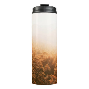 GOLDEN SUN OVER A FOREST THERMAL TUMBLER