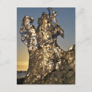 Golden sunrise seen through iceberg formation postcard