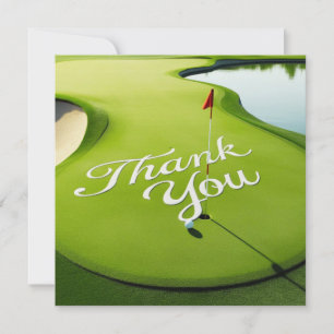 Golf ball on putting green with thank you word card