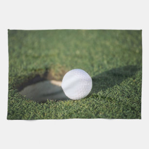 Golf Ball on the edge of hole Tea Towel