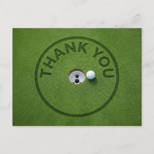 Golf ball with text Thank you on green grass Postcard