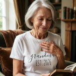 Grandma Est Year Minimalist Elegant Script Design T-Shirt<br><div class="desc">This shirt displays the phrase “Grandma Est Year” in a delicate handwritten style. The simple lettering celebrates the joyful moment of becoming a grandmother. The year text can be edited so the date reflects when this special chapter begins. The minimalist design creates a timeless and elegant look.</div>