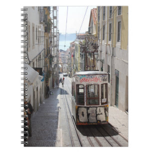 GRAY TRAM ON RAILWAY ALONG THE BUILDING NOTEBOOK