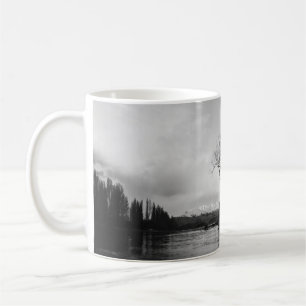 GRAYSCALE PHOTO OF BARE TREE ON CALM BODY OF WATER COFFEE MUG