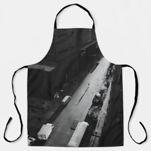 GRAYSCALE PHOTO OF PERSON WALKING ON ROAD OUTSIDE APRON