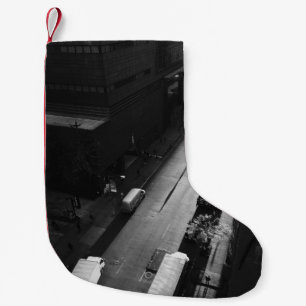 GRAYSCALE PHOTO OF PERSON WALKING ON ROAD OUTSIDE SMALL CHRISTMAS STOCKING