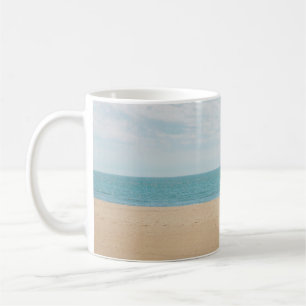 Green artificial palm tree on seashore coffee mug