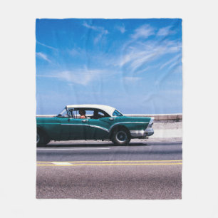 Green coupe on grey asphalt road fleece blanket