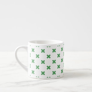 Green cross stitches on white espresso cup