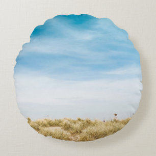 Green grass field under blue skies round cushion