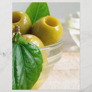 Green marinated olives pitted in a glass cup