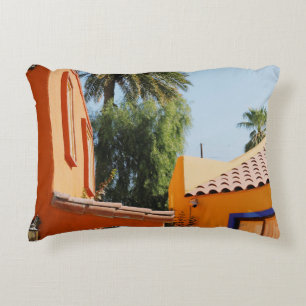 Green palm tree beside brown concrete building in decorative cushion