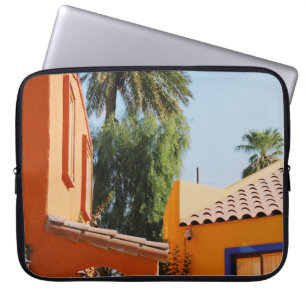 Green palm tree beside brown concrete building in laptop sleeve