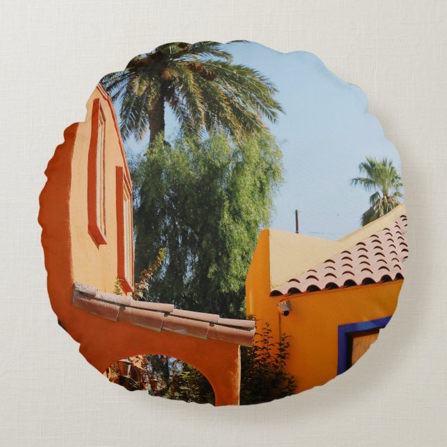 Green palm tree beside brown concrete building in  round cushion (Front)