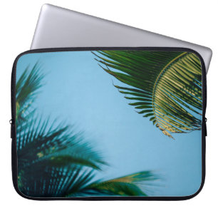 Green palm tree under blue sky in the morning laptop sleeve