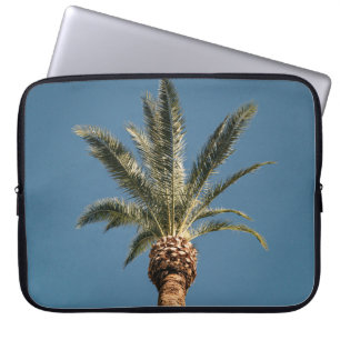 Green palm tree under blue sky in the morning laptop sleeve