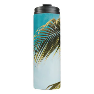 Green palm tree under blue sky thermal tumbler