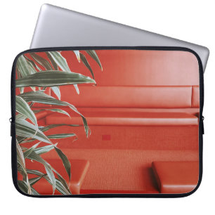 Green plant on red couch laptop sleeve