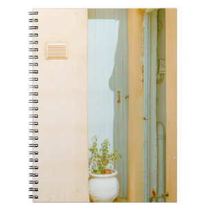 GREEN PLANT WITH CERAMIC VASE BESIDE WHITE WOODEN NOTEBOOK