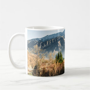 GREEN TREES NEAR SNOW COVERED MOUNTAIN DURING DAYT COFFEE MUG