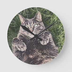grey cat lying in the grass digital art round clock