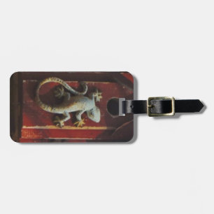 grey lizard on worn wood luggage tag