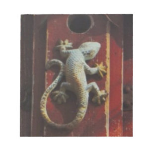grey lizard on worn wood notepad