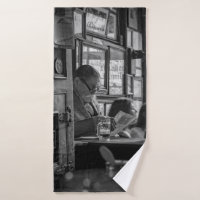 GREYSCALE PHOTO OF MAN SITTING WHILE READING NEWSP