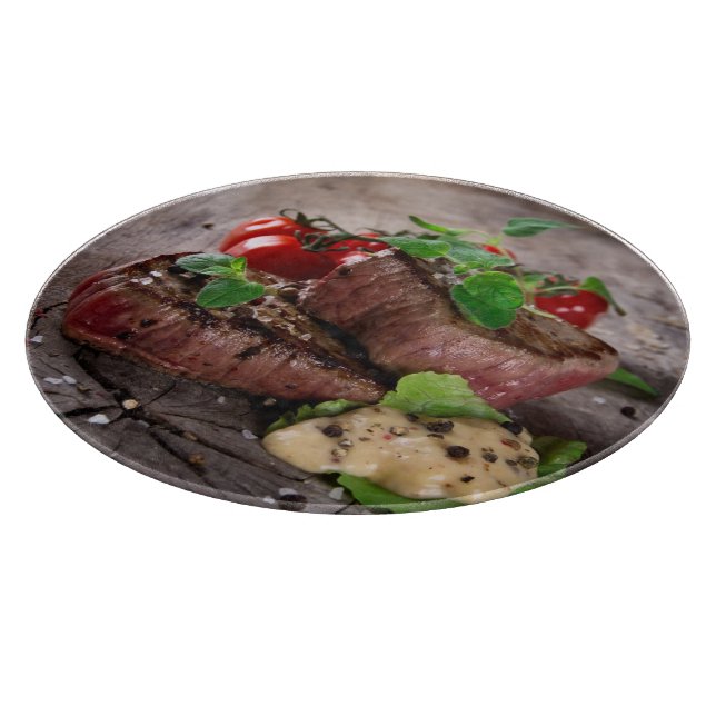 Grilled bbq steaks with fresh herbs and tomatoes cutting board (Corner)