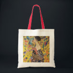 Gustav Klimt Lady With Fan Art Nouveau Painting Tote Bag<br><div class="desc">Gustav Klimt Lady With Fan Art Nouveau Painting This half portrait of a beautiful woman shows a yellow background with asiatic ornaments, colourful birds and lotus flowers. The lady wears a dress in the style of a kimono imprinted with motives of a Chinese dragon dress. Beautiful artistic romantic decorative fine...</div>