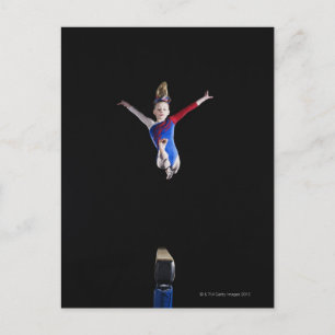 Gymnast (9-10) leaping on balance beam postcard