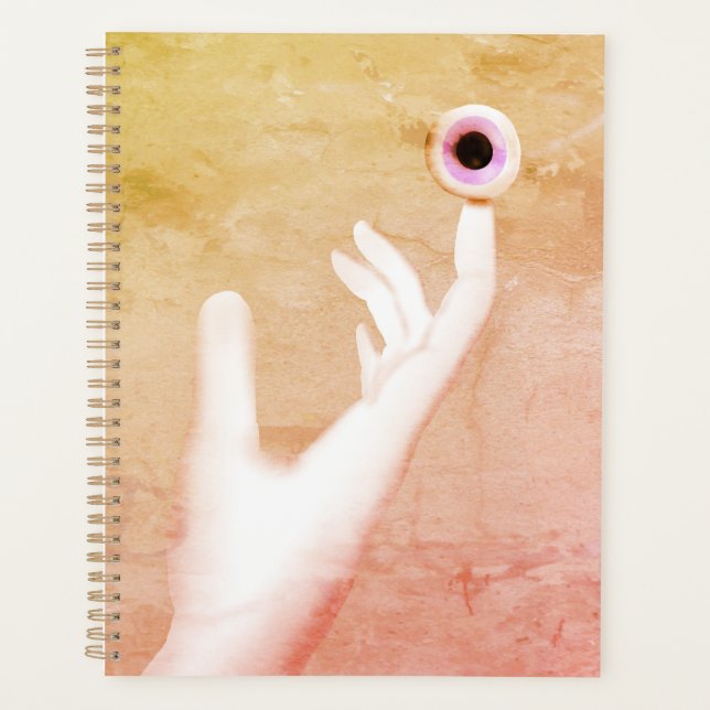Hand holding an eye planner (Front)