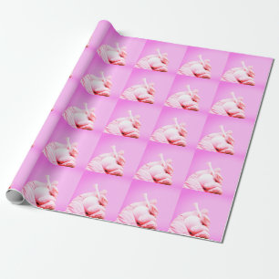 Hand holds golf ball and tee on pink background wrapping paper