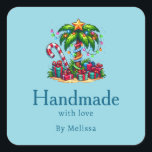 Handmade with Love Tropical Christmas Palm Tree Square Sticker<br><div class="desc">Handmade with Love product stickers with a seasonal holiday image. A tropical palm tree decorated in festive lights with a star on top. A giant red and white candy cane sticking out of the sand. Christmas presents under the tree. Whimsical and fun.</div>