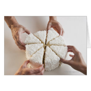 Hands pulling slices from cake