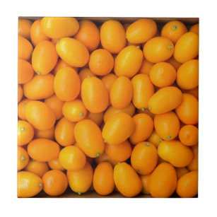 Heap of orange kumquats in cardboard box tile
