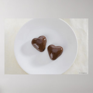 Heart shaped chocolate candies on a plate poster