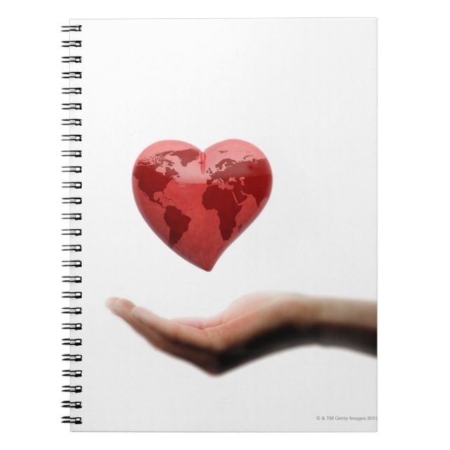 Heart with global map over female hand notebook (Front)
