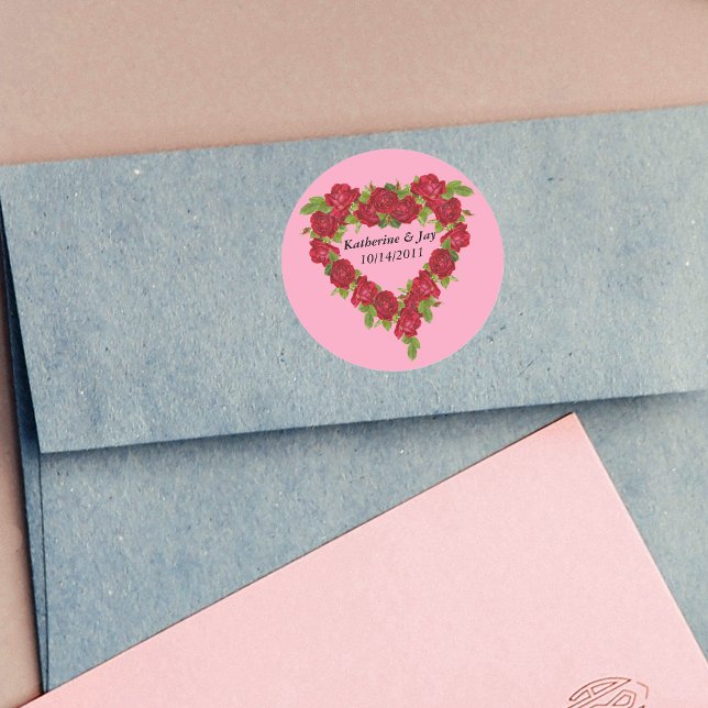 Heart Wreath Red Roses Classic Round Sticker (Heart shaped wreath of red roses leaves for Valentines, or Wedding on pink round stickers.)