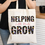 Helping Little Minds Grow Wildflower Lettering Tote Bag<br><div class="desc">Teacher's Tote bag lettered with the slogan "helping little minds grow" and decorated with colourful wildflowers.  The design is printed both sides with a pretty watercolor pattern of meadow wild flowers filling the bold typography. Browse my Teacher Gifts Collection for more teacher gifts.</div>