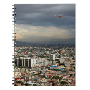 High Angle View Of Cityscape Against Cloudy Sky Spiral Notebook