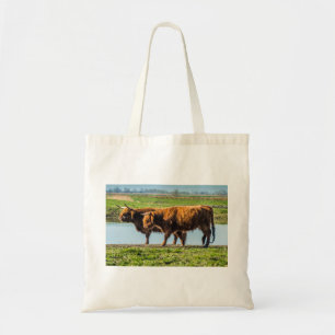 Highland cattle grazing on scenic Wicken Fen UK Tote Bag