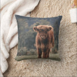 Highland cow calf autumn grass field cushion<br><div class="desc">Highland cow calf autumn grass field photograph. Stunning young calf of highland Scottish cattle on an autumn grassy field with muted colours. Beautiful dark hairy orange coat contrasting with light yellow green grass and trees in bokeh in background.</div>