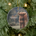 Highland cow calf autumn grass monogram initial ceramic tree decoration<br><div class="desc">Highland cow calf autumn grass field photograph. Stunning young calf of highland scottish cattle on an autumn grassy field with muted colours. Beautiful dark hairy orange coat contrasting with light yellow green grass and trees in bokeh in background. Custom personalizable monogram with your name and inital on the left.</div>