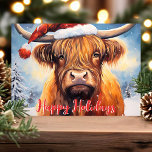 Highland Cow Santa Hat Cute Christmas Holiday Card<br><div class="desc">Celebrate the holiday season with this adorable Christmas card featuring a charming Highland cow wearing a Santa hat. The festive scene includes snow-covered trees and a cheerful "Happy Holidays" greeting in red. Perfect for adding a touch of whimsy and warmth to your holiday greetings, this card is sure to bring...</div>