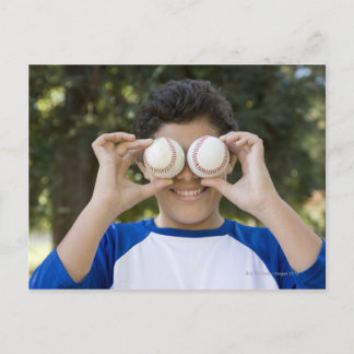 Hispanic teenage boy covering eyes with postcard