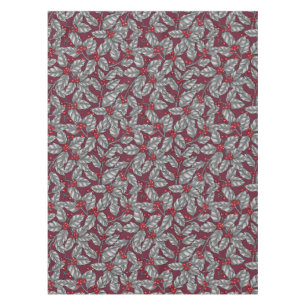 Holly berry, grey leaves on dark red tablecloth
