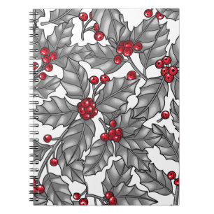 Holly berry, grey leaves on white notebook