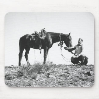 Horse eating from a cowboy's hat. mouse pad